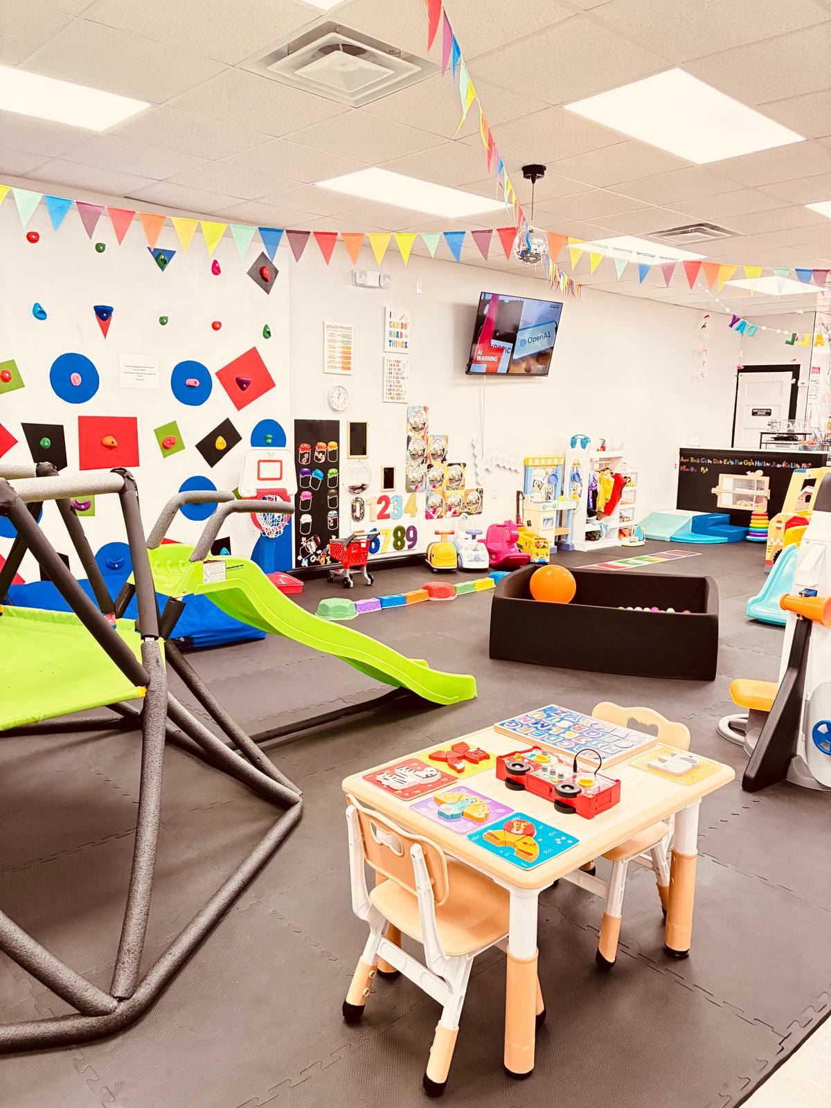 Slide, climbing wall, and toddler activity table at JJ's